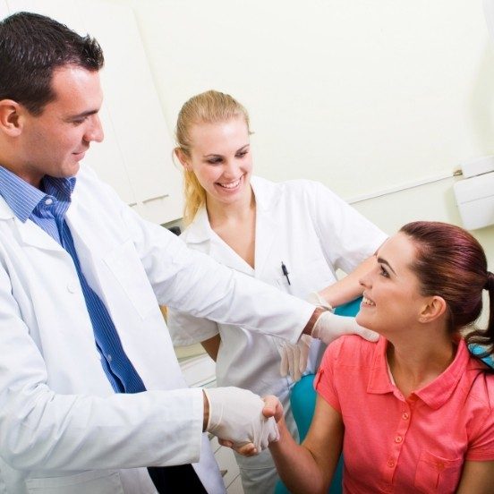 Dentist shaking hands with dental patient