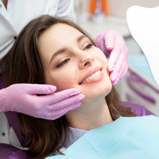 Happy patient using mirror to admire results of BioClear treatment