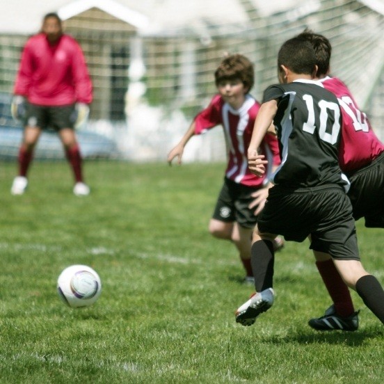 Kids playing soccer with protective athletic mouthguards