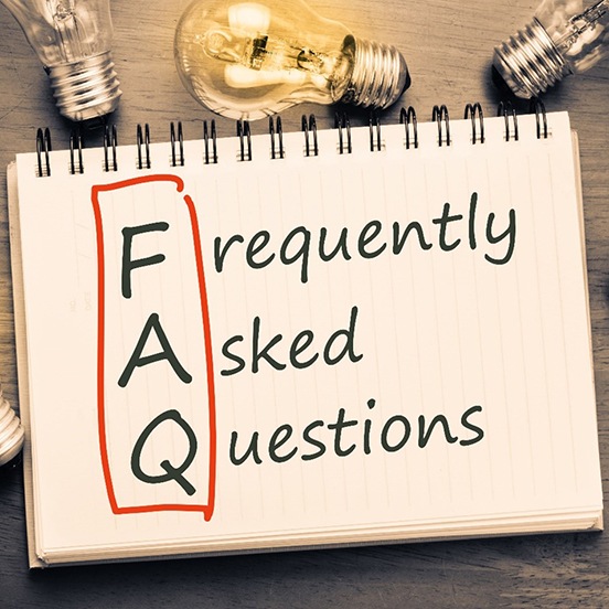 Frequently asked questions written on notepad surrounded by lightbulbs