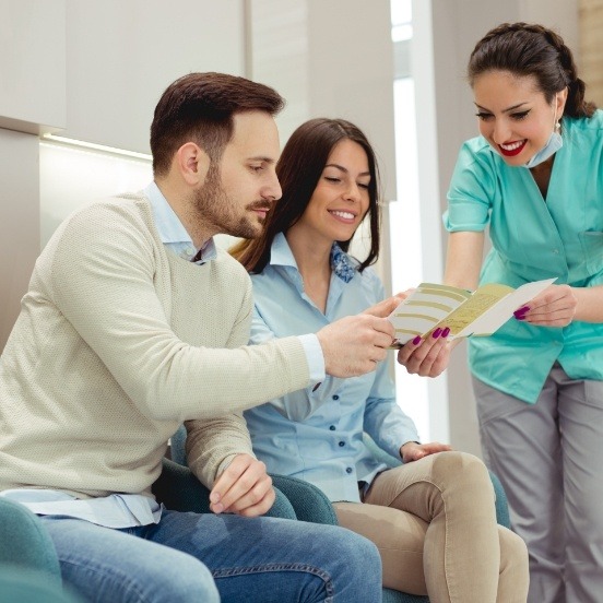 Dental team members and patient reviewing how dental insurance works