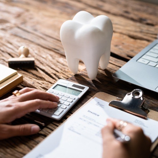 Dentist calculating what dental insurance covers