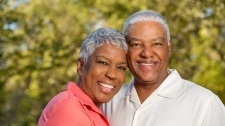 Man and woman smiling after restorative denitstry treatment