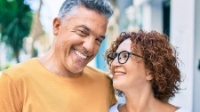 Man and woman with healthy smiles after replacing missing teeth