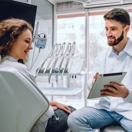 Dentist and patient looking at cavity detection system results